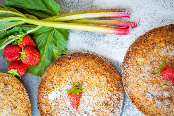 3 Tarts Topped With Strawberries With Rhubarb Beside Them